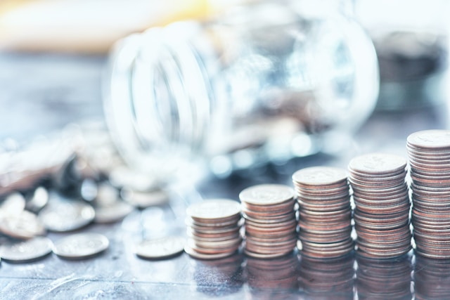 A pile of coins spilling out of a glass jar