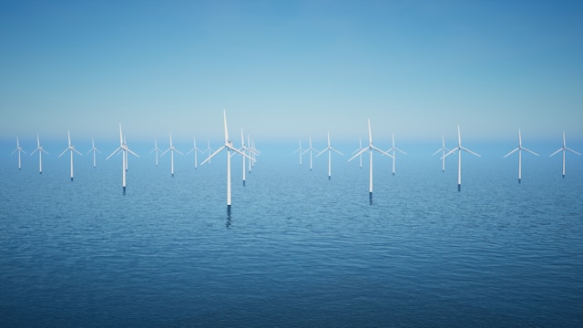 A windmill farm on a blue ocean